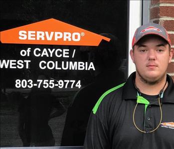 young male with grey hat, black polo shirt, orange SERVPRO logo