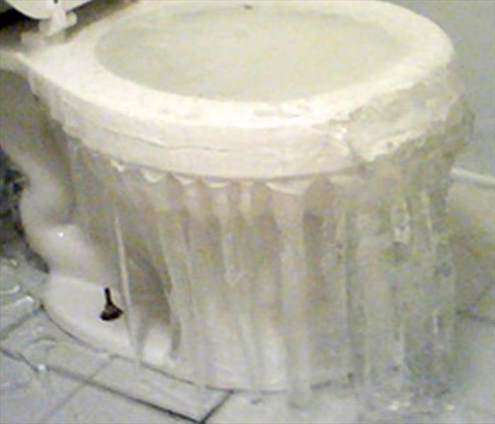 A white overflowing toilet. 